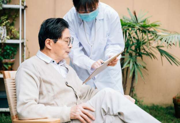Senior man with young female doctor in the yard