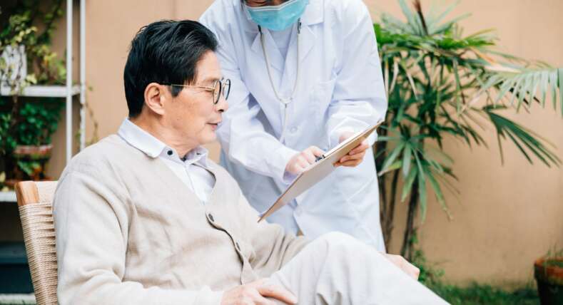 Senior man with young female doctor in the yard