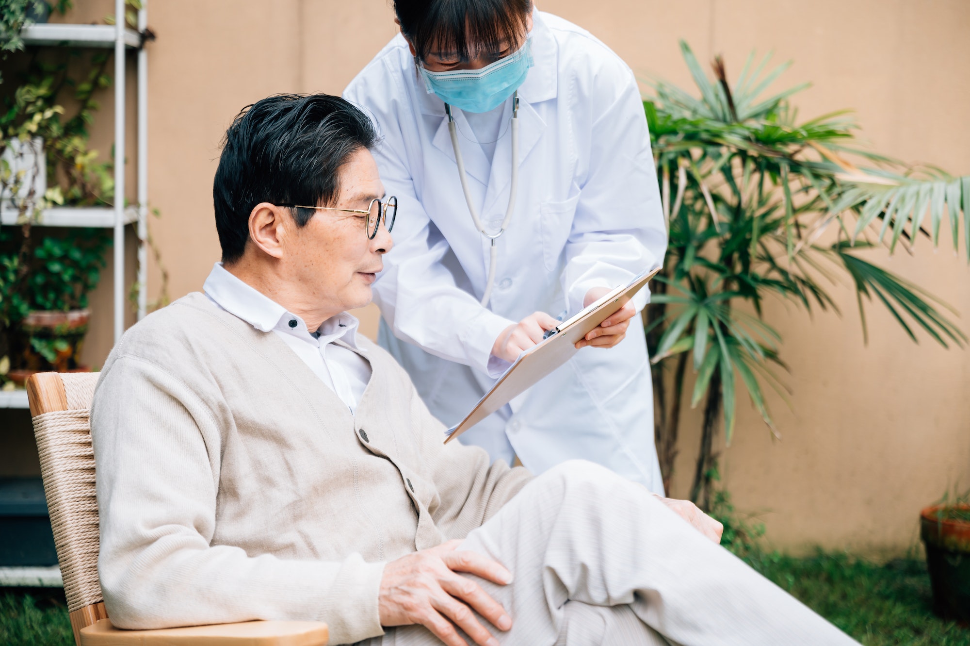 Senior man with young female doctor in the yard